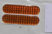 Pružná odrazka plastická ohebná samolepicí oranžová cca 7 x 2,5cm